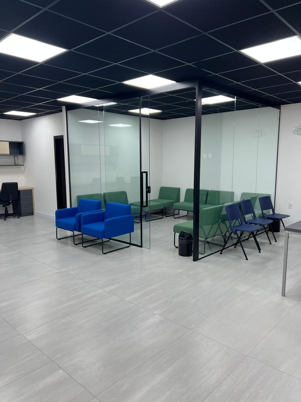 Depois: área de espera com poltronas azuis e salas com divisórias de vidro